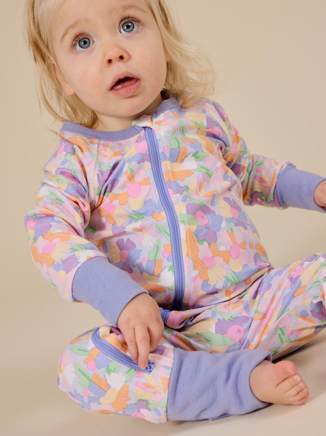 The Goldie + Ace Pastel Bouquet Zipsuit in Lilac Multi pictured on a transparent background. The material is soft cotton elastane. It is a zipsuit made for babies, toddlers and kids.