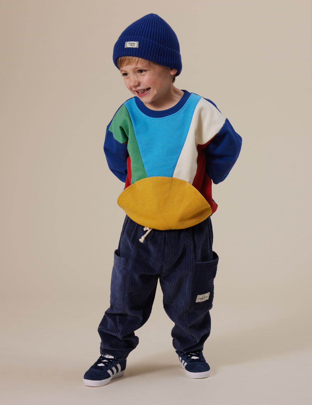 The Goldie + Ace Catching Some Rays Terry Sweater in Primary Multi pictured on a grey background. The material is cotton terry. It is a top made for babies, toddlers and kids.