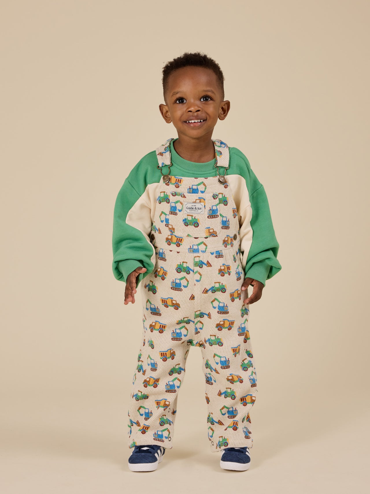 The Goldie + Ace Diggers Austin Overalls in Sand pictured on a transparent background. The material is durable & soft cotton-linen blend. It is a overall made for babies, toddlers and kids.