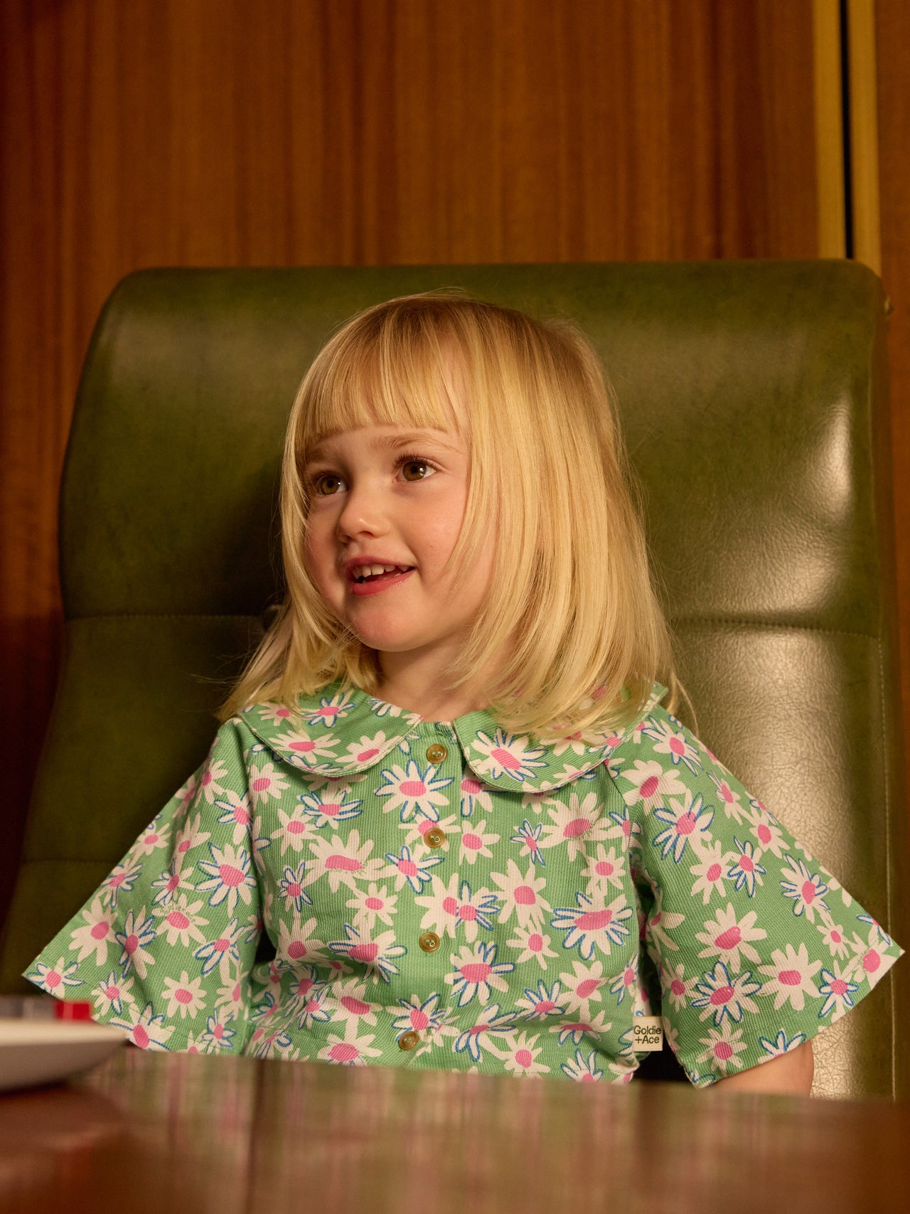 The Goldie + Ace Daisy Patch Abigail Blouse in Moss pictured on a transparent background. The material is breathable cotton-linen blend. It is a top made for babies, toddlers and kids.