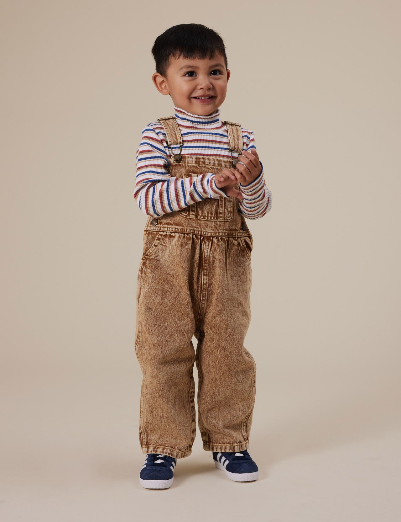 The Goldie + Ace Austin Vintage Washed Denim Overalls in Brown pictured on a grey background. The material is cotton denim. It is a overall made for babies, toddlers and kids.