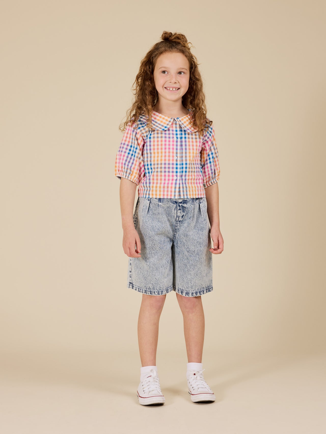 The Goldie + Ace Rainbow Gingham Beatrice Blouse in Multi pictured on a transparent background. The material is 100% cotton. It is a top made for babies, toddlers and kids.