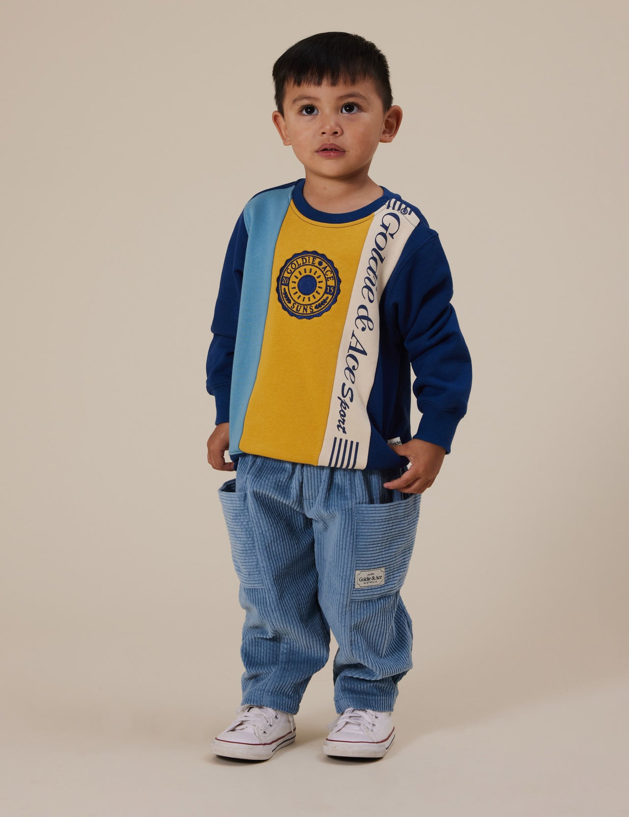 The Goldie + Ace Goldie Sports Day Terry Sweater in Navy pictured on a grey background. The material is cotton terry. It is a top made for babies, toddlers and kids.