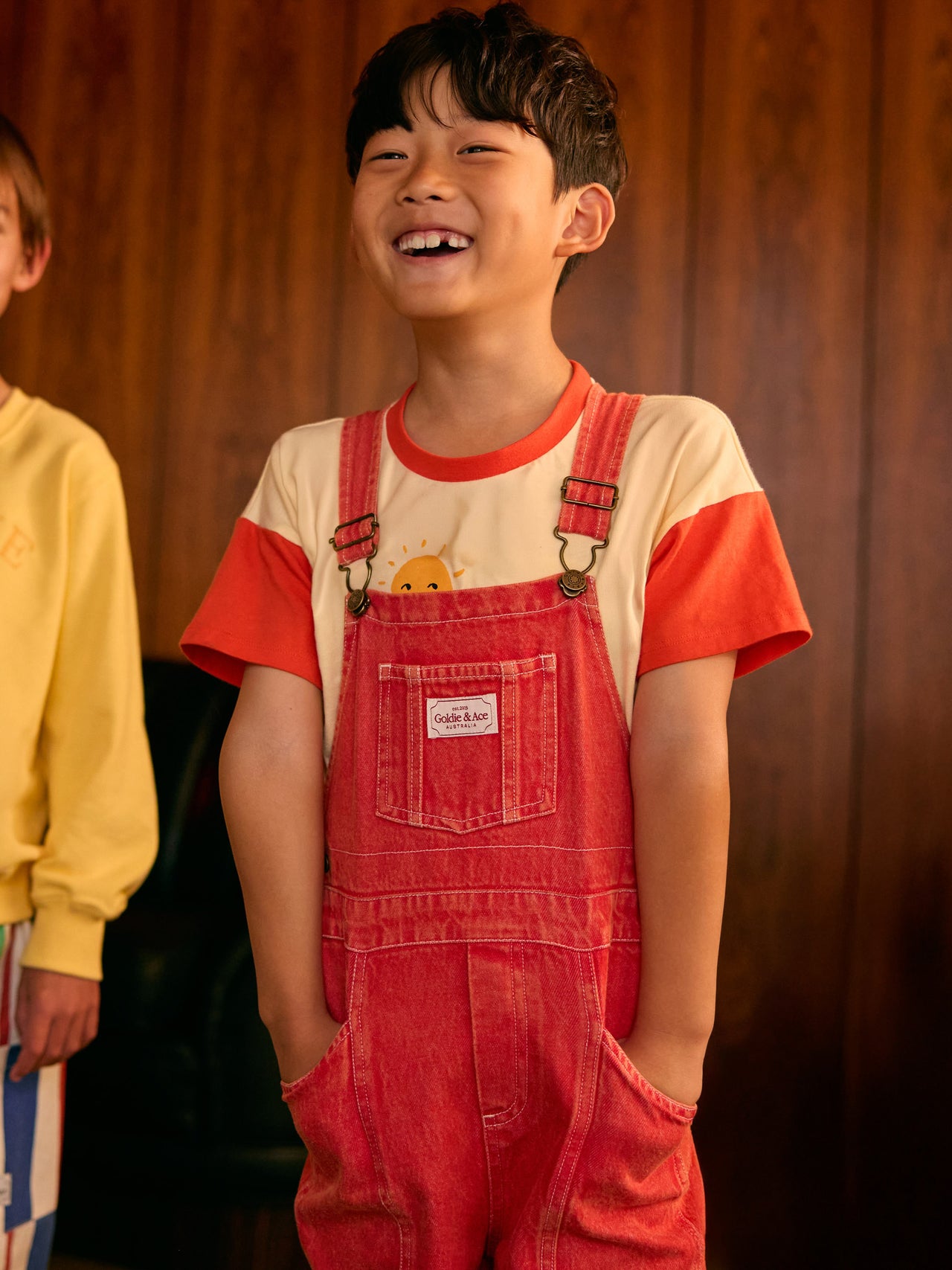 The Goldie + Ace James Vintage Washed Denim Pocket Overalls in Apple Red pictured on a transparent background. The material is 100% cotton. It is a overall made for babies, toddlers and kids.
