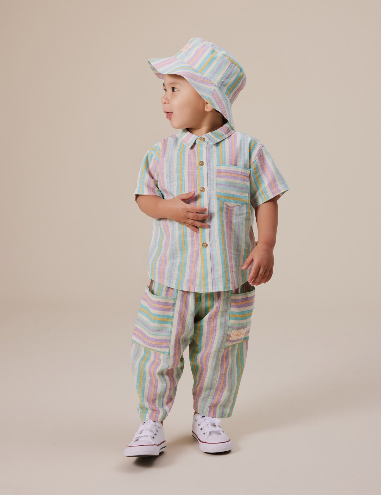 The Goldie + Ace Kit Linen Pocket Pant in Resort Stripe pictured on a grey background. The material is linen. It is a bottom made for babies, toddlers and kids.