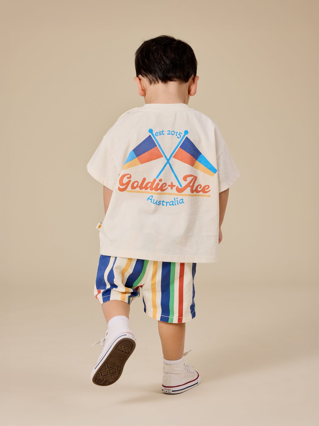 The Goldie + Ace Nautical Flag Oversized T-Shirt in Cream pictured on a transparent background. The material is 100% cotton. It is a top made for babies, toddlers and kids.