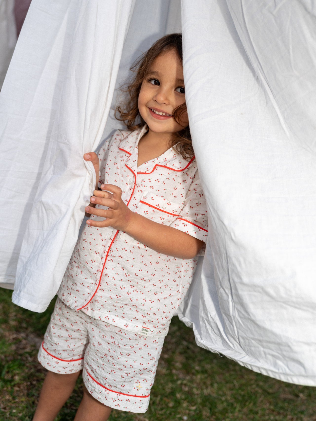 Children's pyjama set with cherry print on seersucker cotton, and a matching drawstring bag