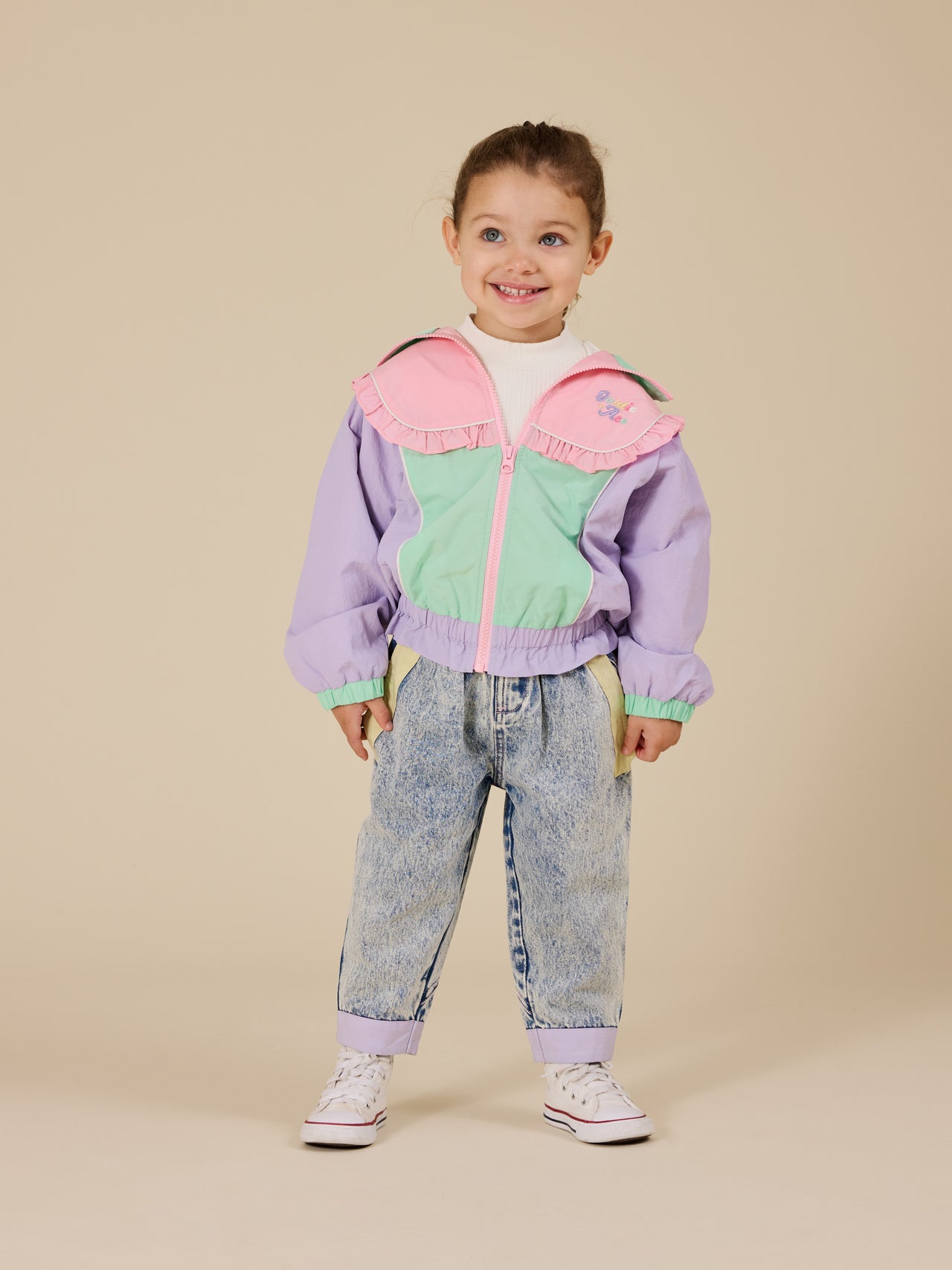 The Goldie + Ace Frill Seekers Retro Spray Jacket in Lilac/Rose/Peapod pictured on a transparent background. The material is poly with cotton lining. It is a jacket made for babies, toddlers and kids.