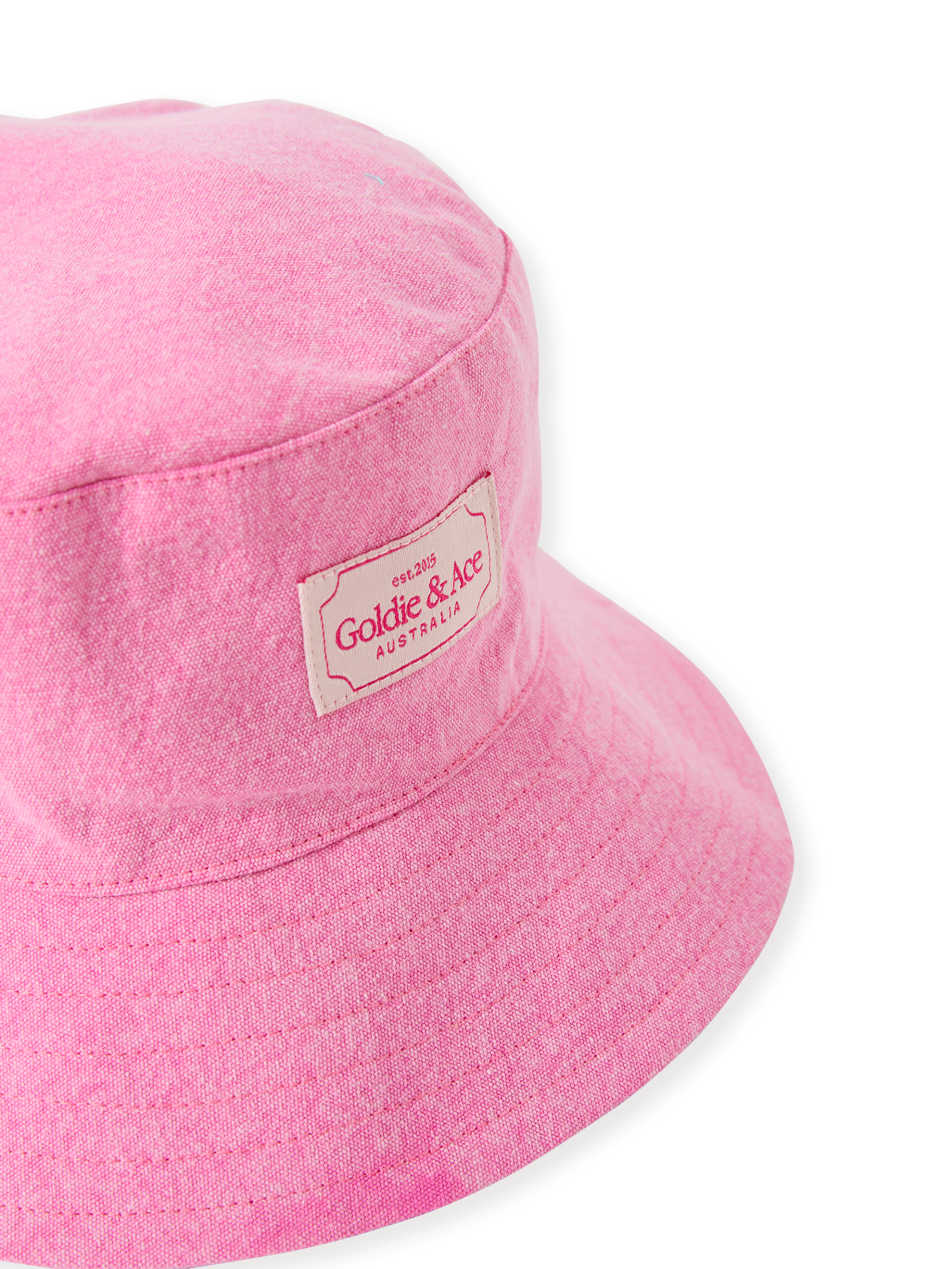 The Goldie + Ace Denim Bucket Hat in Pink Lemonade pictured on a transparent background. The material is cotton with cotton lining. It is a accessory made for babies, toddlers and kids.