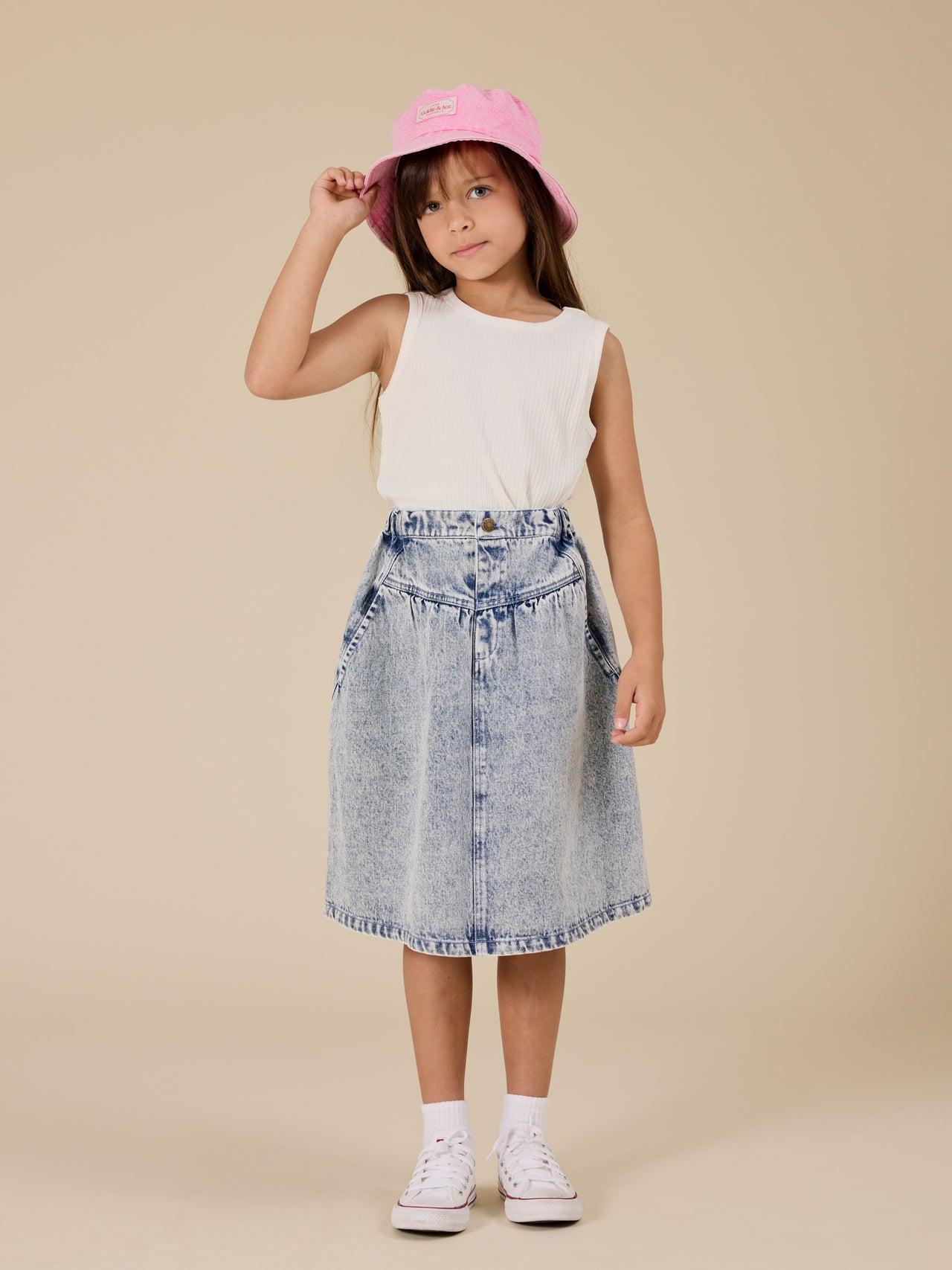 The Goldie + Ace Esta A-Line Denim Skirt in Light Denim pictured on a transparent background. The material is 100% cotton. It is a bottom made for babies, toddlers and kids.