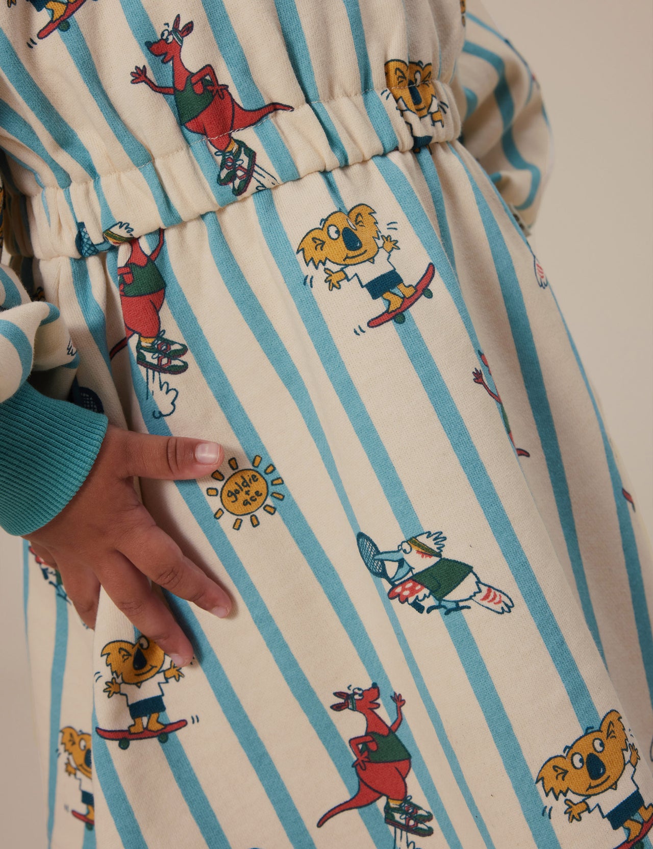 The Goldie + Ace Goldie Squad Leah Long Sleeve Dress in Vanilla/Dusty Blue pictured on a grey background. The material is cotton terry. It is a dress made for babies, toddlers and kids.