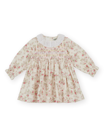 The Goldie + Ace Strawberry Fields Smocked Dress in Cream pictured on a transparent background. The material is 100% cotton. It is a dress made for babies, toddlers and kids.