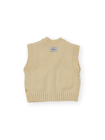 The Goldie + Ace Apple Pocket Knit Vest in Cream pictured on a transparent background. The material is 15%wool 15%nylon 70%acrylic. It is a knit made for babies, toddlers and kids.