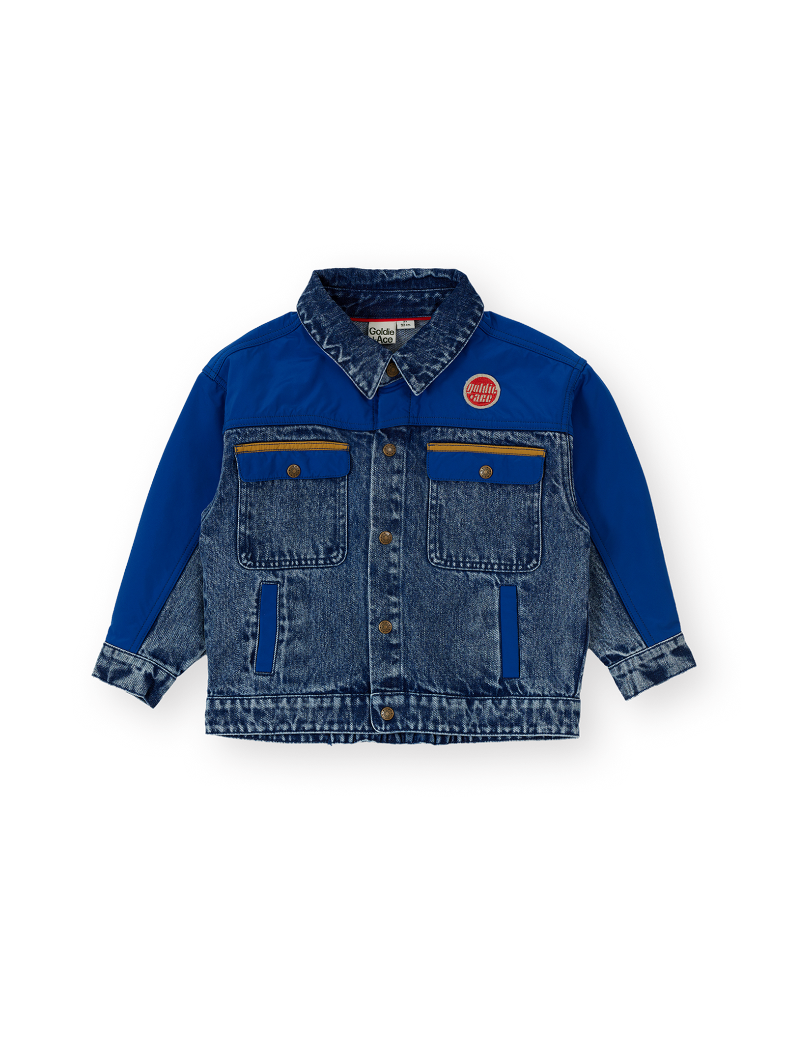 The Goldie + Ace Colour Block Vintage Denim Jacket in Dark Denim & Multi pictured on a transparent background. The material is 100% cotton, 100% polyester coloured panels, 100% cotton lining. It is a jacket made for babies, toddlers and kids.