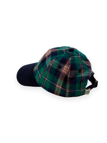 The Goldie + Ace Tate Check Cap in Green Check pictured on a transparent background. The material is 100% cotton with 100% cotton lining. It is a hat made for babies, toddlers and kids.
