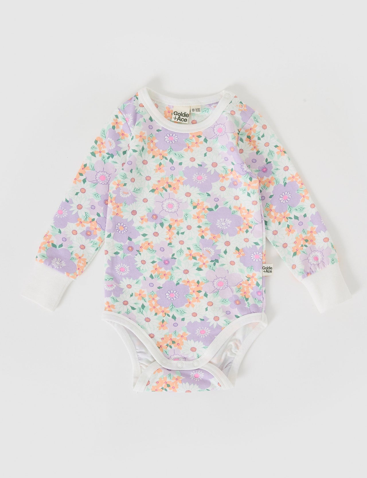 The Goldie + Ace Flora Long Sleeve Bodysuit in Lilac Multi pictured on a grey background. The material is soft cotton elastane. It is a babywear made for babies, toddlers and kids.