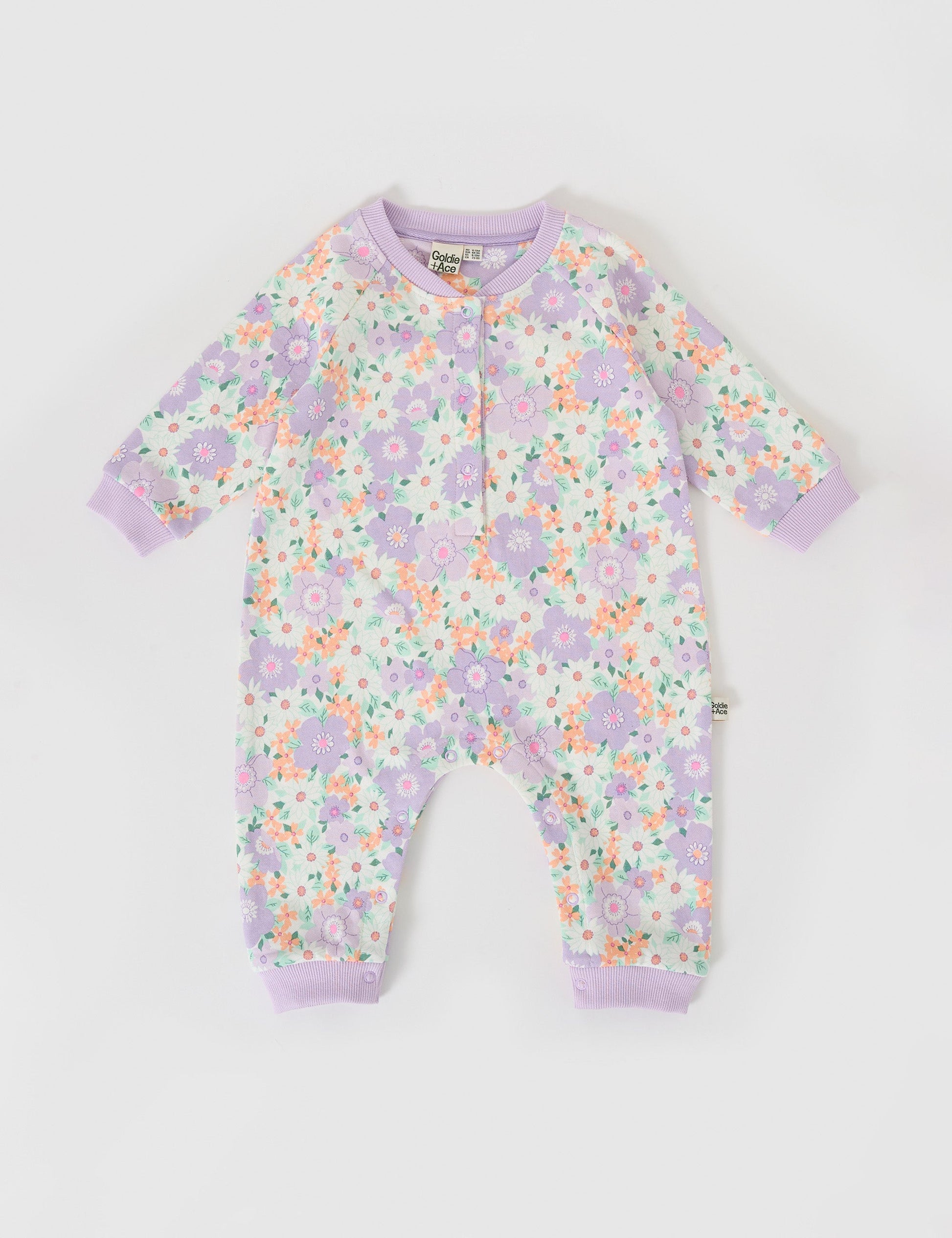 The Goldie + Ace Flora Relaxed Terry Romper in Lilac Multi pictured on a grey background. The material is cotton terry. It is a babywear made for babies, toddlers and kids.