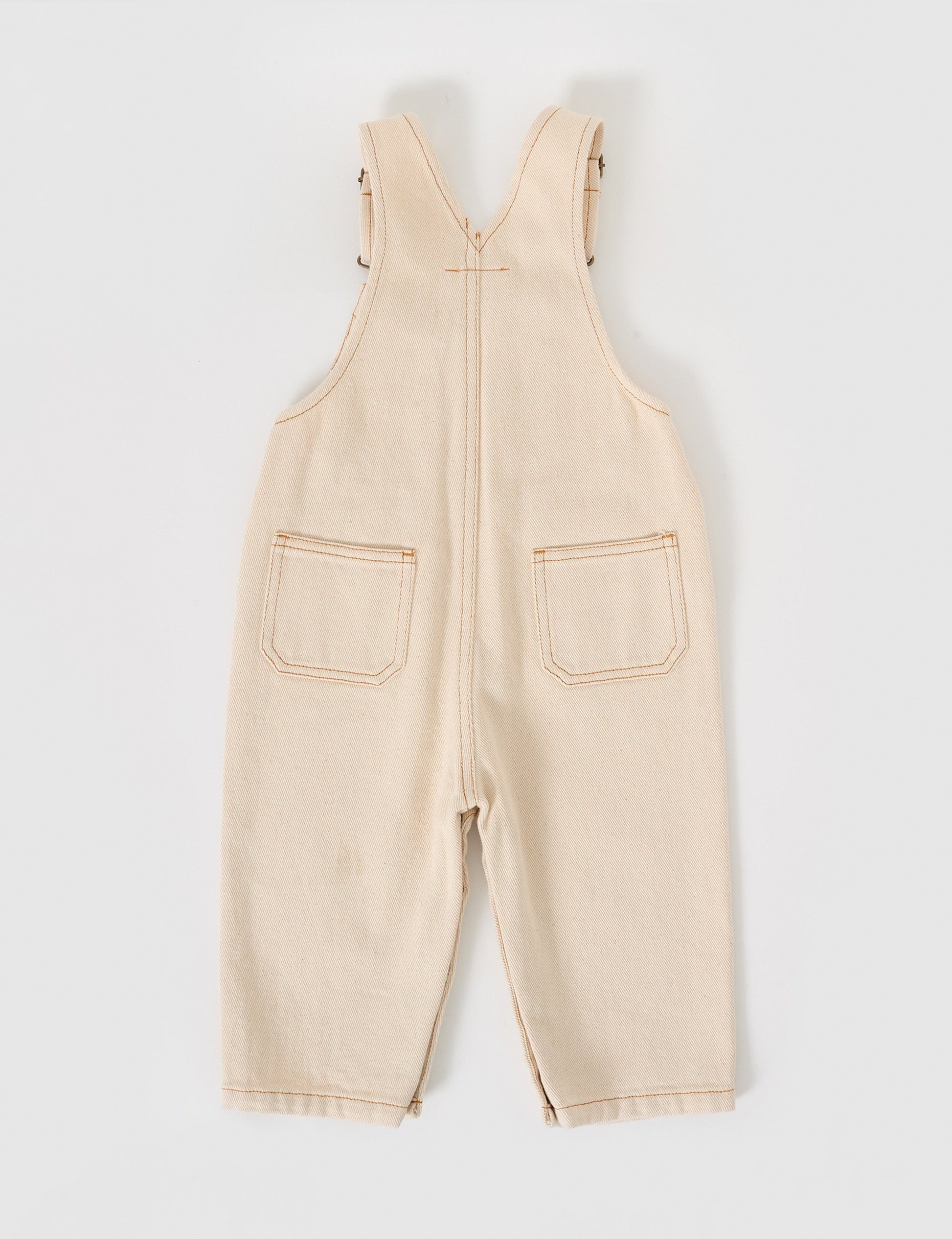 The Goldie + Ace Austin Denim Overalls in Oat pictured on a grey background. The material is cotton denim. It is a overall made for babies, toddlers and kids.