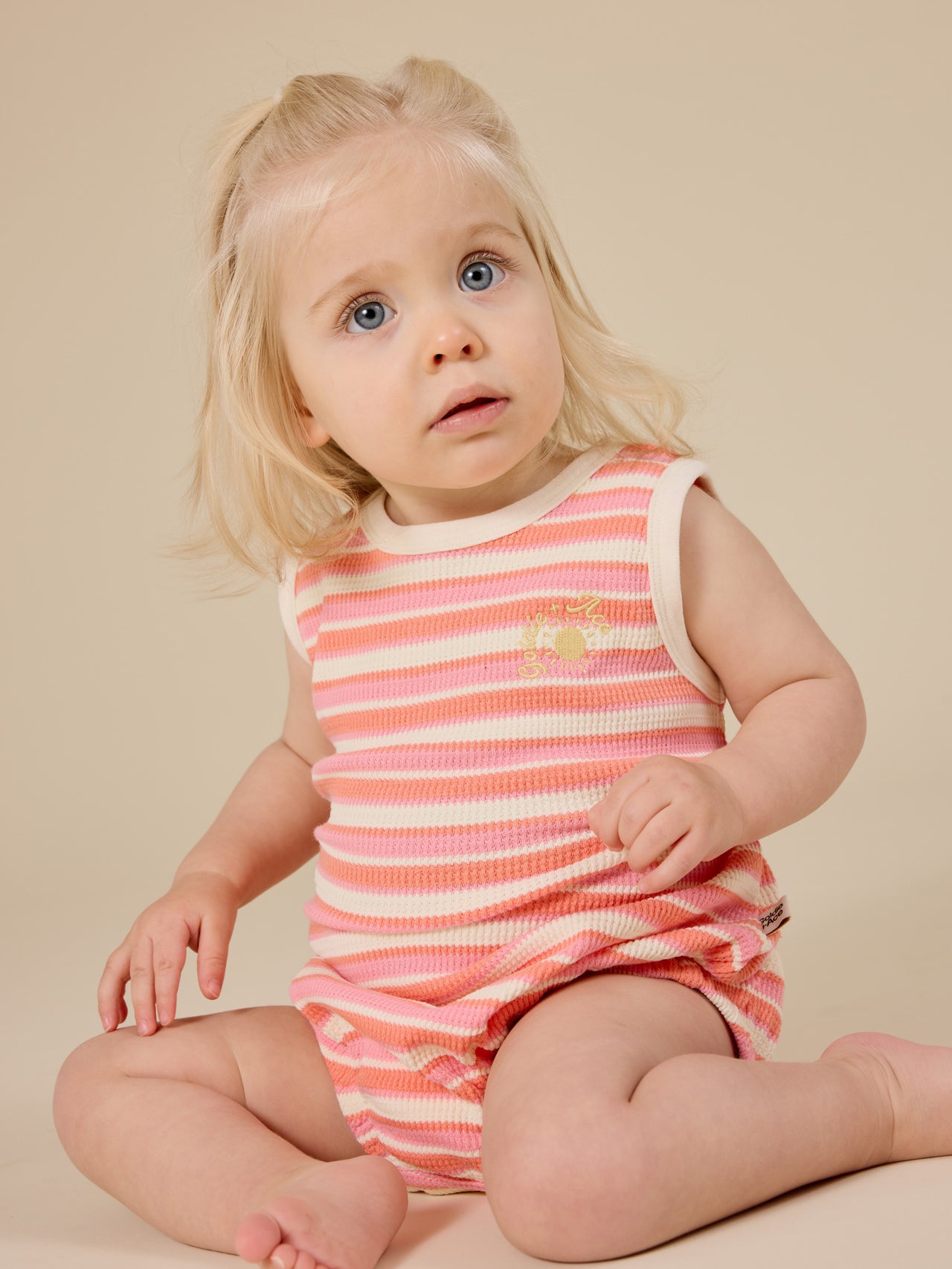 The Goldie + Ace Watermelon Stripe Bubble Romper in Pink/Peach pictured on a transparent background. The material is 100% cotton. It is a romper made for babies, toddlers and kids.