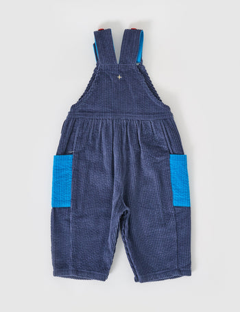 The Goldie + Ace Sammy Corduroy Colour Block Overalls in Blue/Red pictured on a grey background. The material is cotton denim. It is a overall made for babies, toddlers and kids.