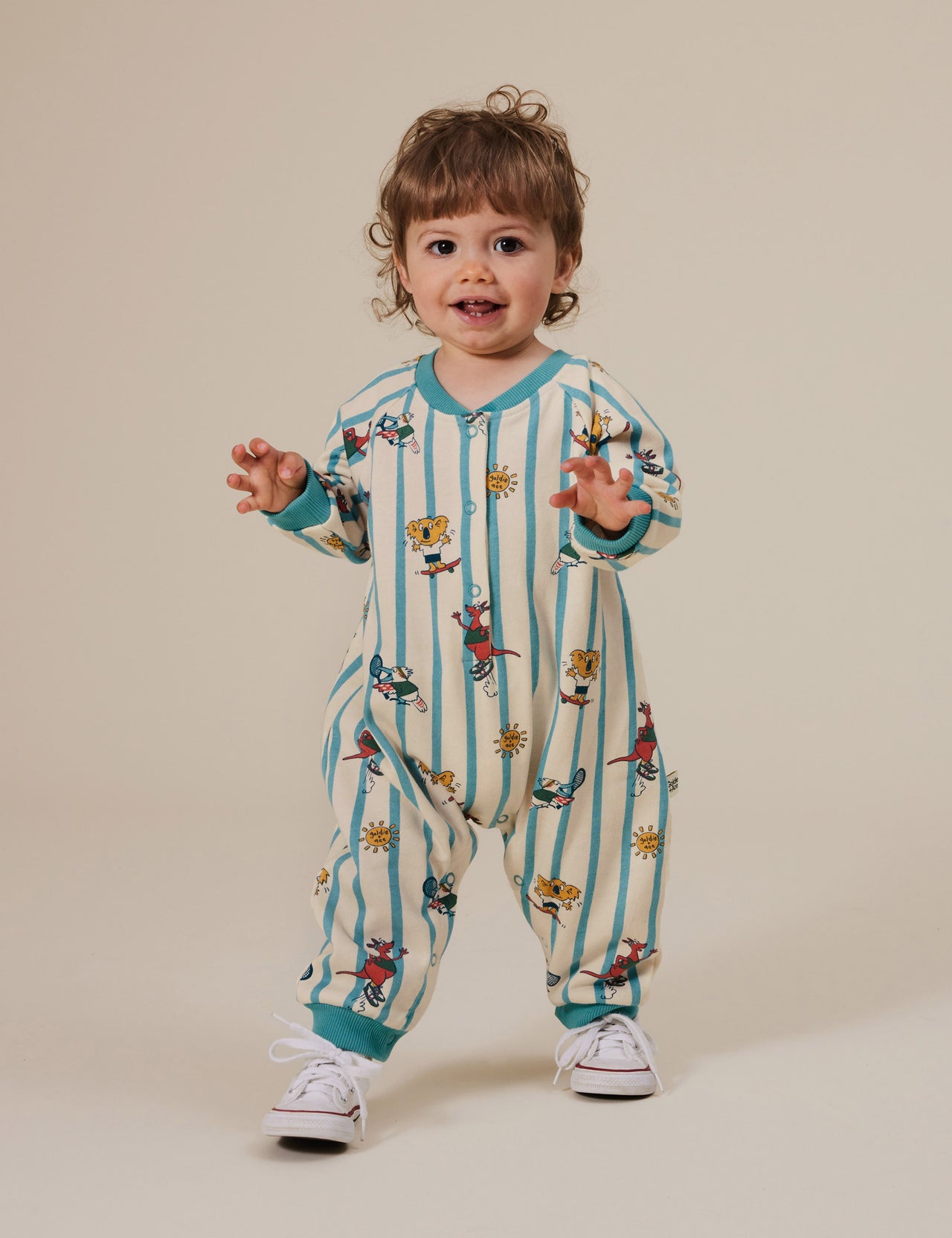 The Goldie + Ace Goldie Squad Relaxed Terry Romper in Vanilla/Dusty Blue pictured on a grey background. The material is cotton terry. It is a babywear made for babies, toddlers and kids.