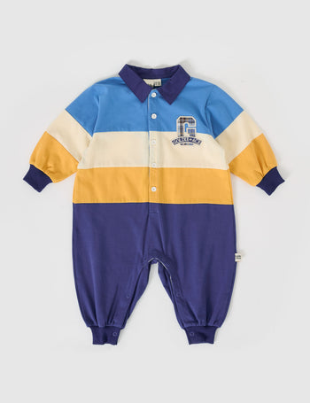 The Goldie + Ace Panelled Rugby Romper in Blue/Golden pictured on a grey background. The material is cotton jersey. It is a romper made for babies, toddlers and kids.