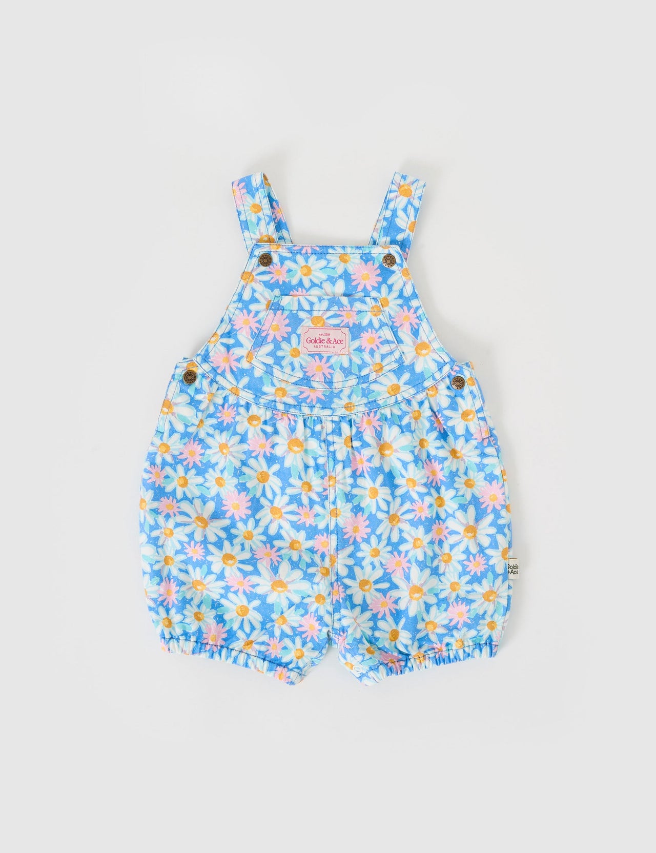 The Goldie + Ace Seaside Daisy Bessie Bubble Shortalls in Seaside Daisy pictured on a grey background. The material is cotton twill. It is a overall made for babies, toddlers and kids.