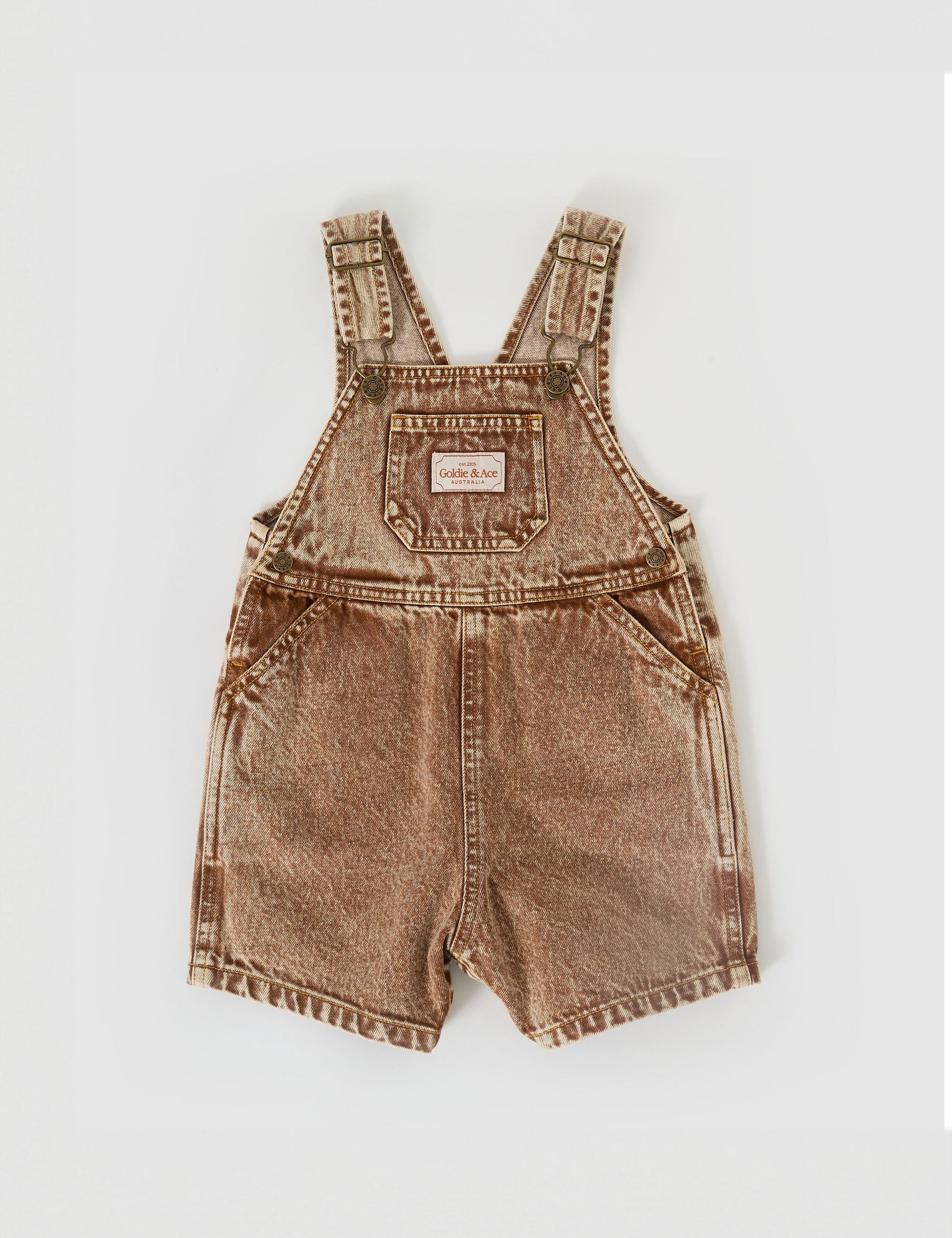 The Goldie + Ace Burton Vintage Washed Denim Overalls in Brown pictured on a grey background. The material is cotton denim. It is a overall made for babies, toddlers and kids.