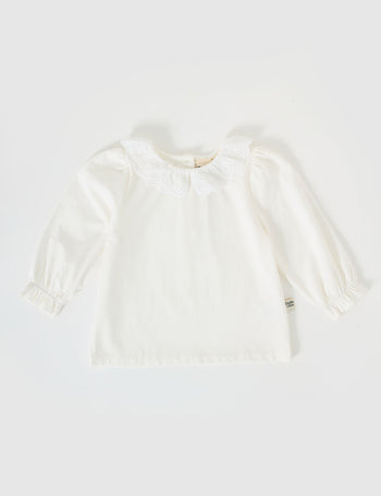 The Goldie + Ace Laura Puff Sleeve Collar Long Sleeve in White pictured on a grey background. The material is cotton jersey. It is a top made for babies, toddlers and kids.