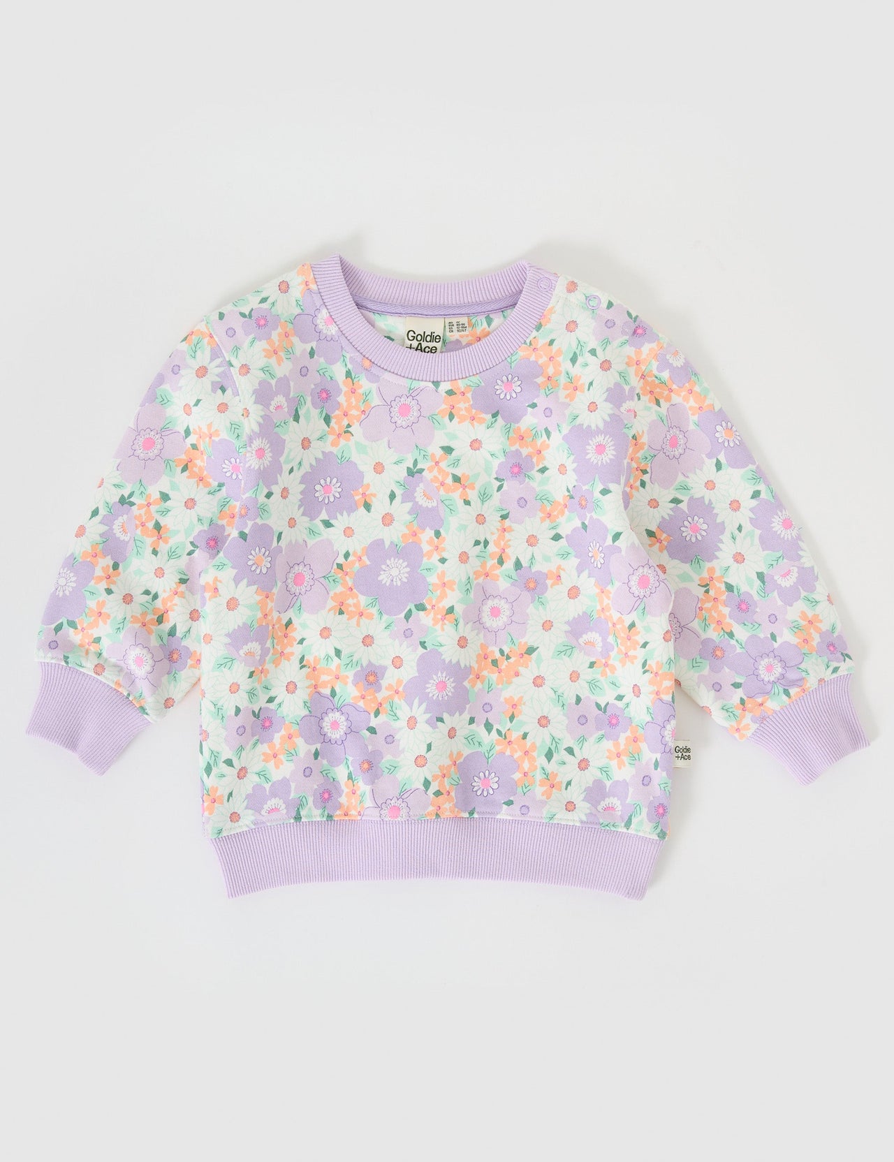 The Goldie + Ace Flora Relaxed Terry Sweater in Lilac Multi pictured on a grey background. The material is cotton terry. It is a top made for babies, toddlers and kids.