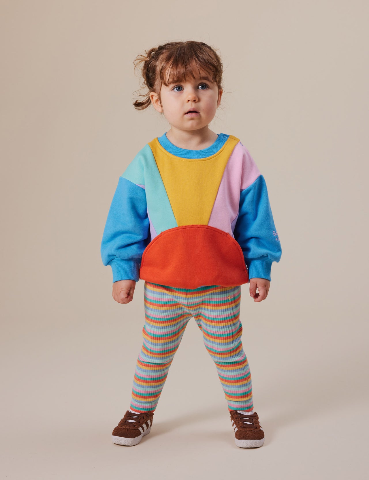 The Goldie + Ace Catching Some Rays Terry Sweater in Bright Multi pictured on a grey background. The material is cotton terry. It is a top made for babies, toddlers and kids.