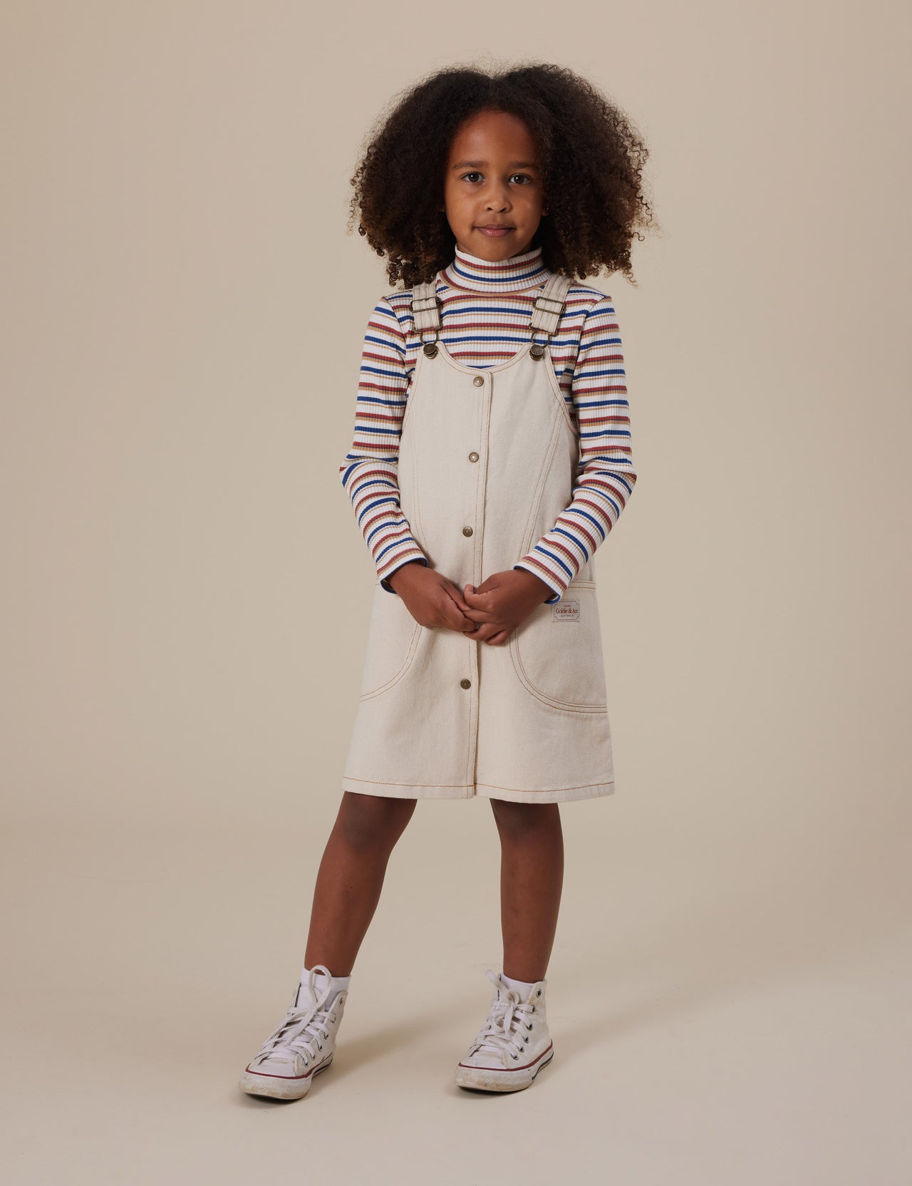 The Goldie + Ace Outback Stripe Embroidered Rib Skivvy in Outback Stripe pictured on a grey background. The material is soft ribbed cotton elastane. It is a top made for babies, toddlers and kids.