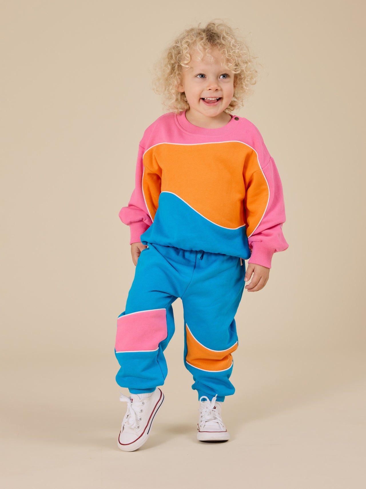 The Goldie + Ace Nash Piped Panel Sweatshirt in Sunrise pictured on a transparent background. The material is 100% cotton. It is a top made for babies, toddlers and kids.