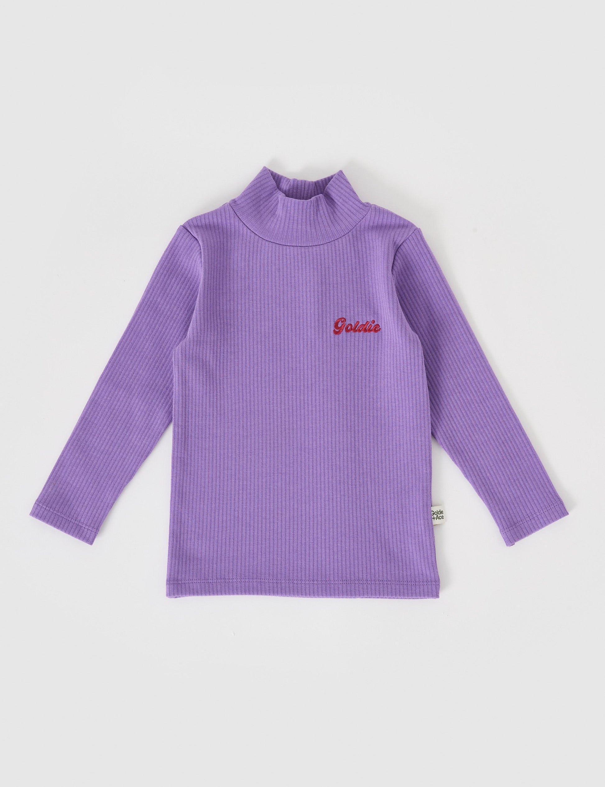 The Goldie + Ace Embroidered Rib Skivvy Grape in Grape pictured on a grey background. The material is soft ribbed cotton elastane. It is a top made for babies, toddlers and kids.