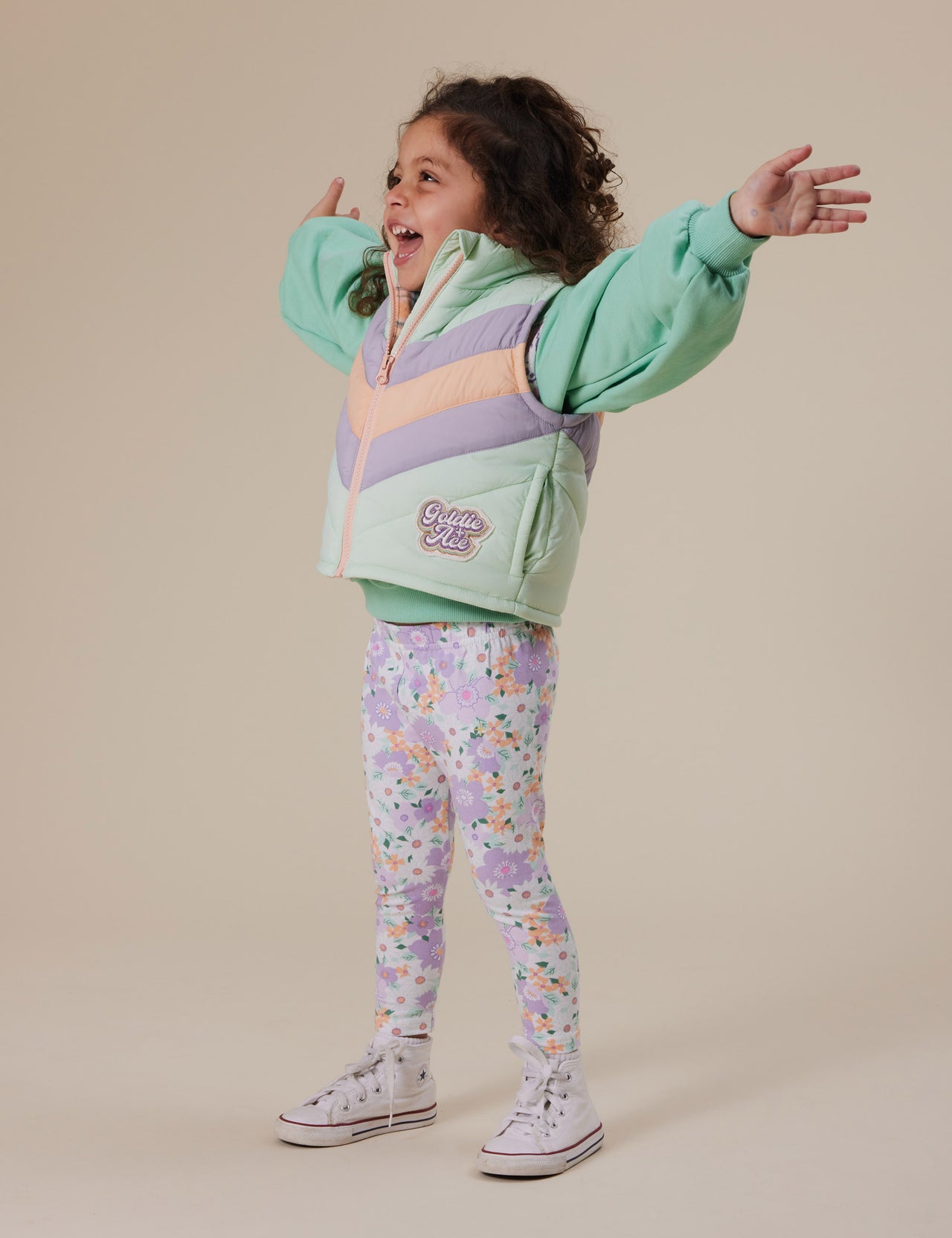 The Goldie + Ace Flora Leggings in Lilac Multi pictured on a grey background. The material is soft cotton elastane. It is a bottom made for babies, toddlers and kids.