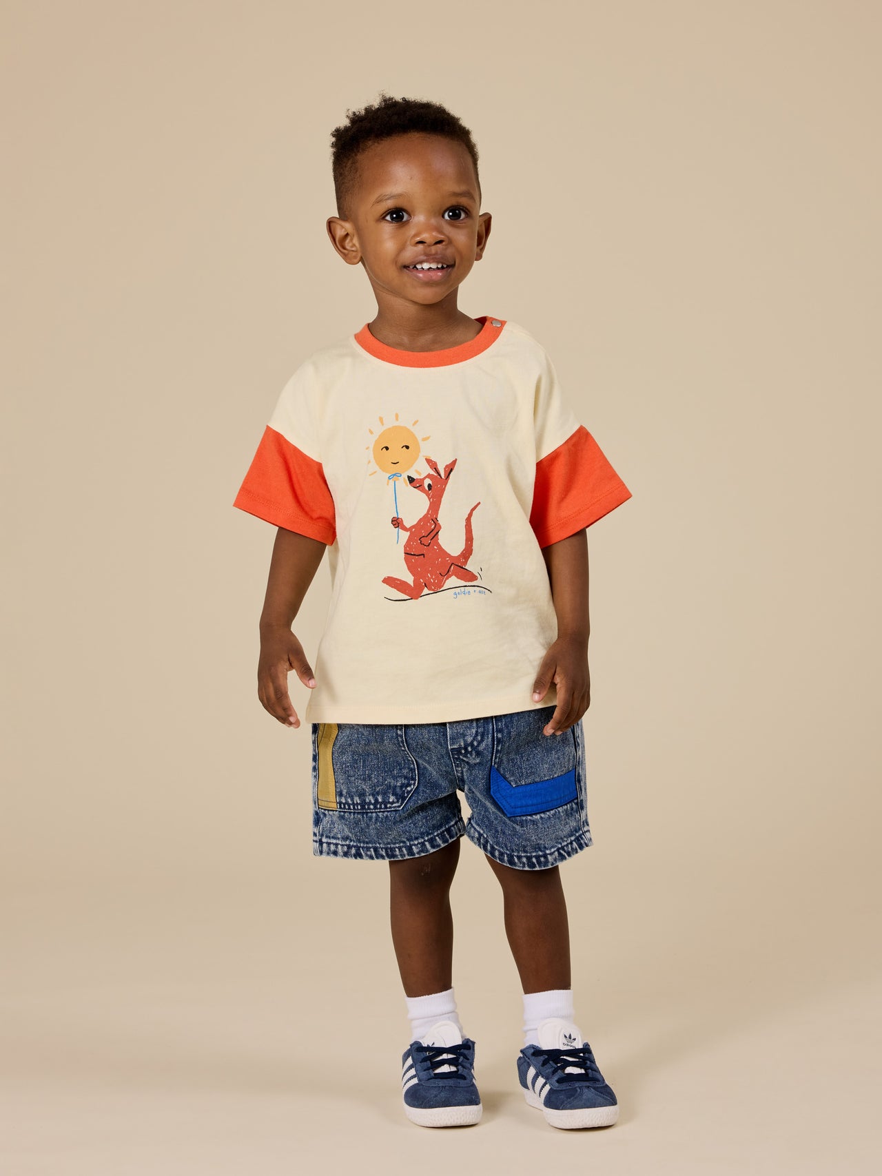 The Goldie + Ace Primary Pop Noah Denim Shorts in Dark Denim pictured on a transparent background. The material is 100% cotton. It is a bottom made for babies, toddlers and kids.