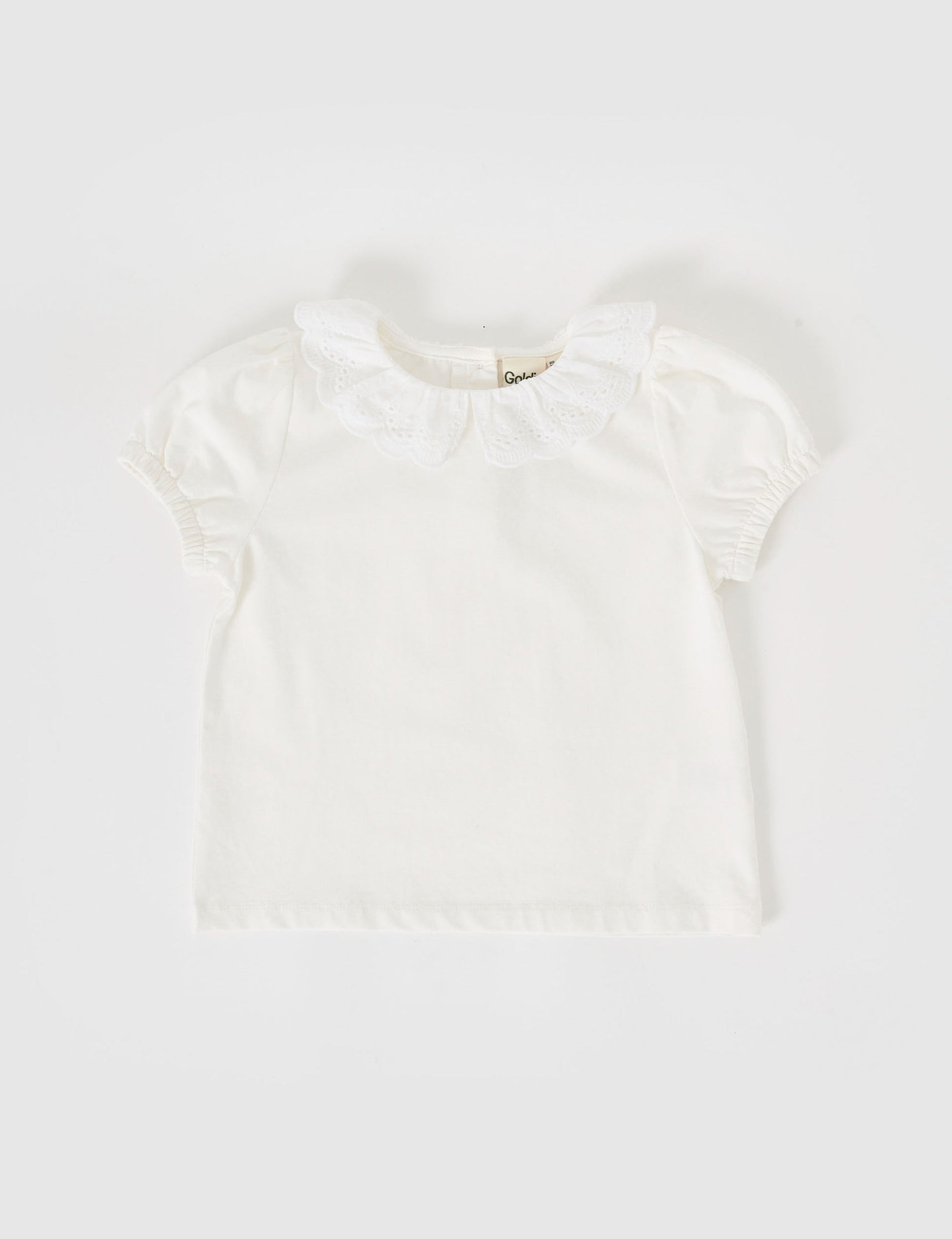 The Goldie + Ace Laura Puff Sleeve Collar Top in White pictured on a grey background. The material is cotton jersey. It is a top made for babies, toddlers and kids.