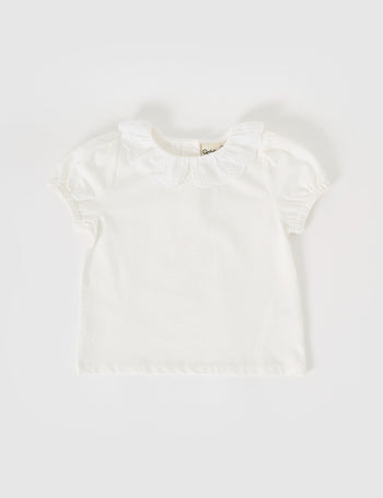 The Goldie + Ace Laura Puff Sleeve Collar Top in White pictured on a grey background. The material is cotton jersey. It is a top made for babies, toddlers and kids.