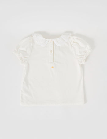 The Goldie + Ace Laura Puff Sleeve Collar Top in White pictured on a grey background. The material is cotton jersey. It is a top made for babies, toddlers and kids.