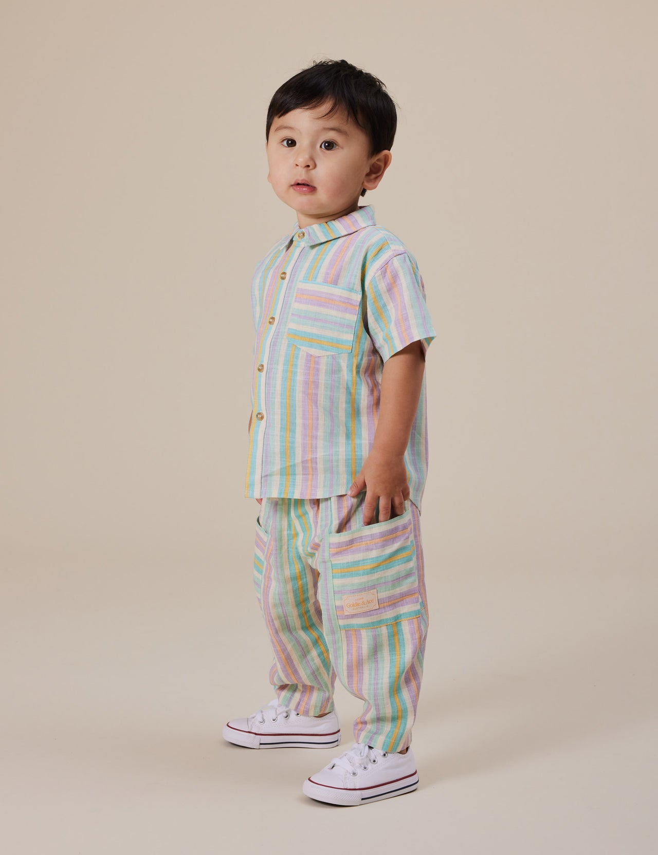 The Goldie + Ace Kit Linen Pocket Pant in Resort Stripe pictured on a grey background. The material is linen. It is a bottom made for babies, toddlers and kids.