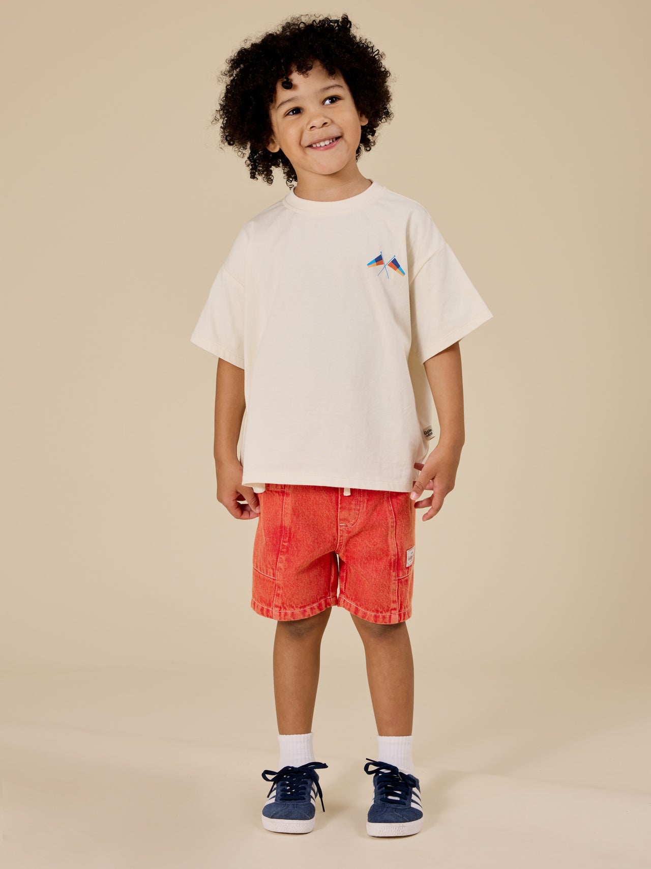 The Goldie + Ace Noah Denim Pocket Shorts in Apple Red pictured on a transparent background. The material is 100% cotton. It is a bottom made for babies, toddlers and kids.