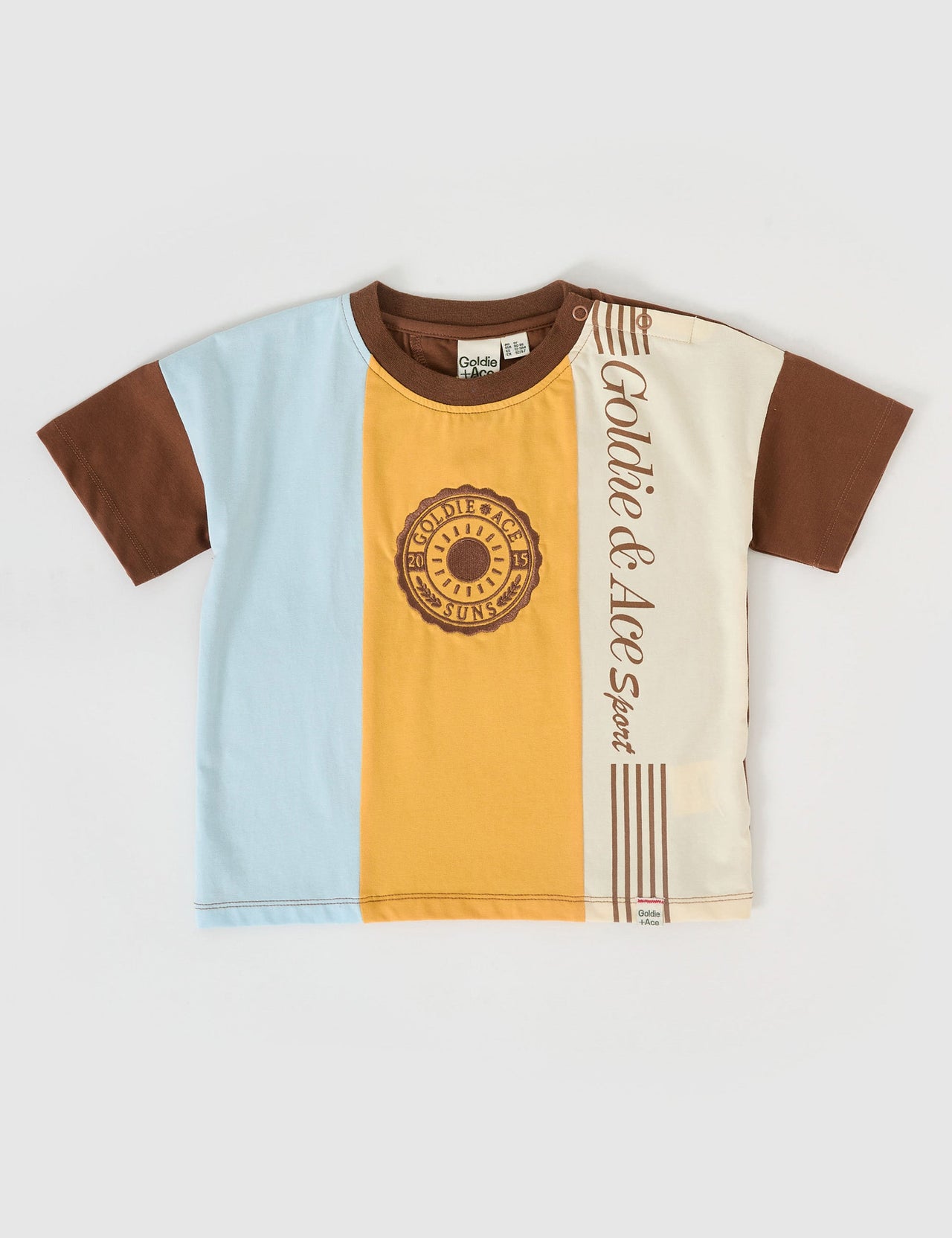 The Goldie + Ace Goldie Sports Day T-Shirt in Brown Golden Cream Blue pictured on a grey background. The material is cotton jersey. It is a top made for babies, toddlers and kids.