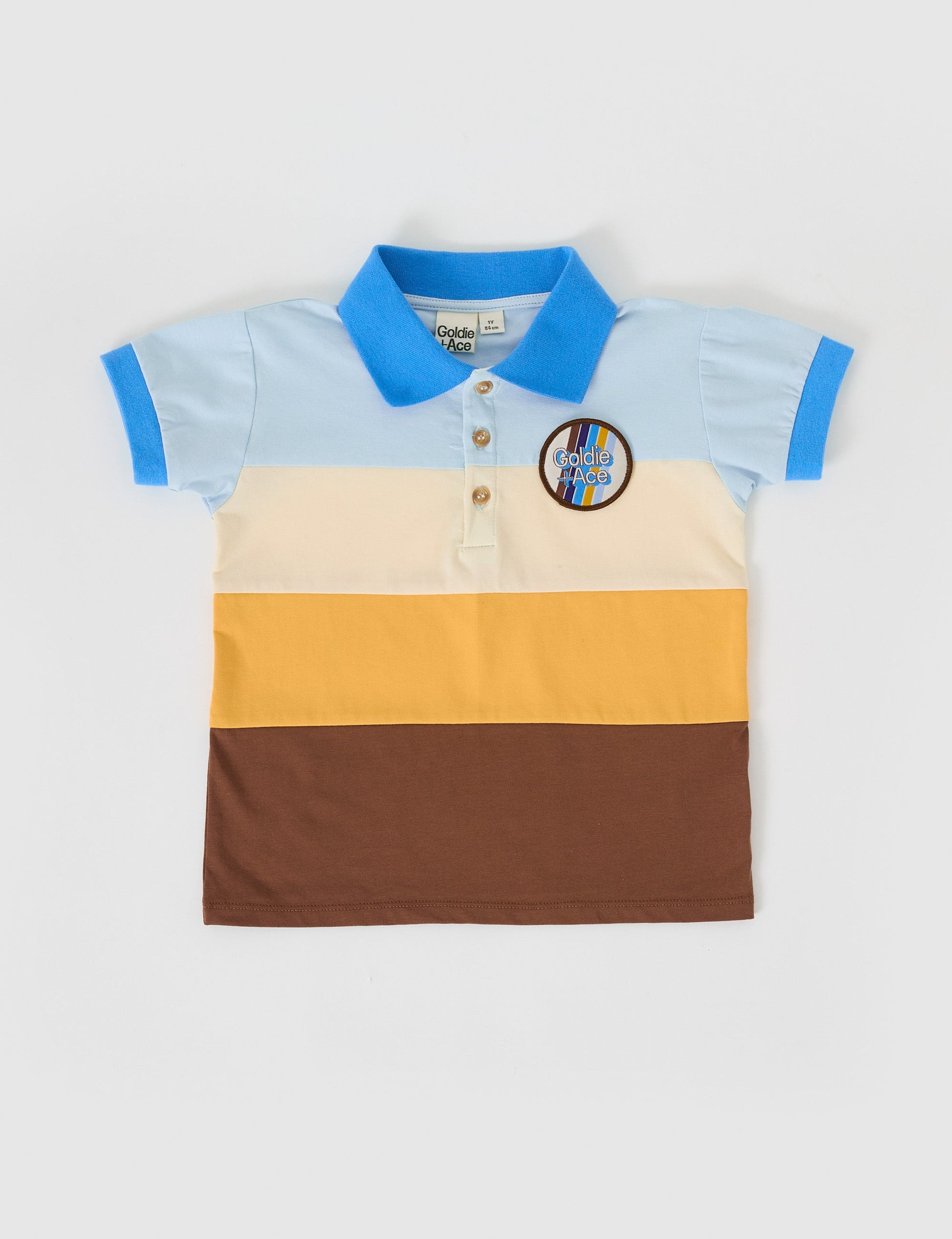 The Goldie + Ace Tommy Polo Shirt in Brown Golden Cream Blue pictured on a grey background. The material is cotton jersey. It is a top made for babies, toddlers and kids.