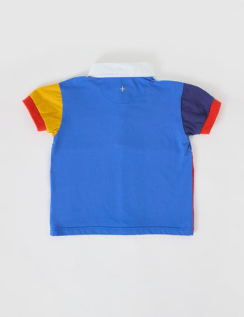 The Goldie + Ace Myles Colour Block Polo Shirt in Primary Multi pictured on a grey background. The material is cotton jersey. It is a top made for babies, toddlers and kids.