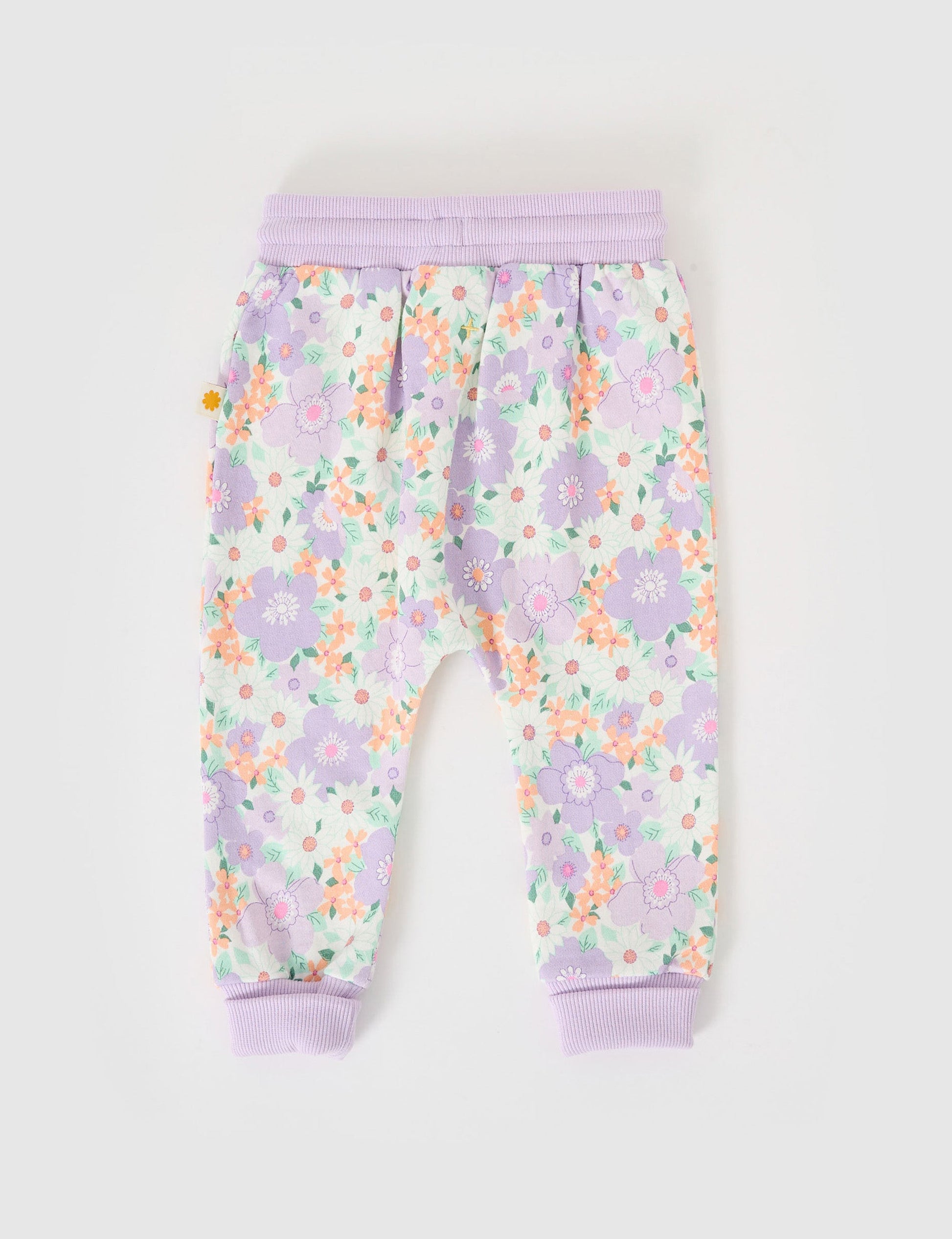 The Goldie + Ace Flora Terry Sweatpants in Lilac Multi pictured on a grey background. The material is cotton terry. It is a bottom made for babies, toddlers and kids.