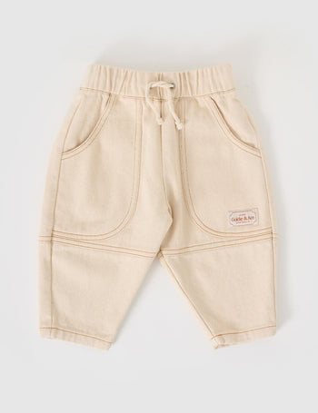 The Goldie + Ace Drew Denim Pocket Pant in Oat pictured on a grey background. The material is cotton denim. It is a bottom made for babies, toddlers and kids.