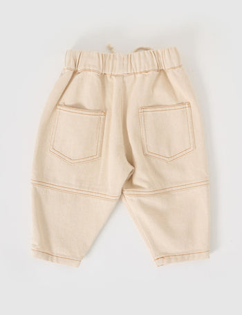 The Goldie + Ace Drew Denim Pocket Pant in Oat pictured on a grey background. The material is cotton denim. It is a bottom made for babies, toddlers and kids.