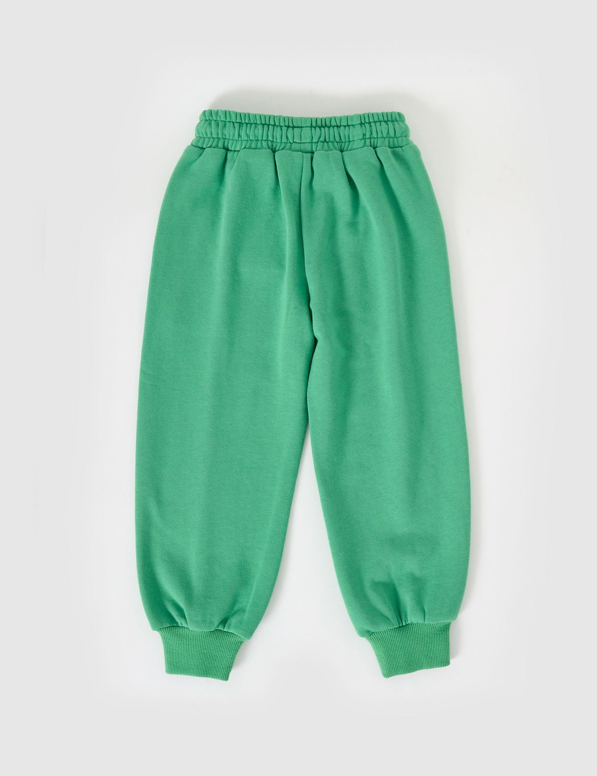 The Goldie + Ace Goldie Sports Day Trackie Pants in Green pictured on a grey background. The material is cotton terry. It is a bottom made for babies, toddlers and kids.