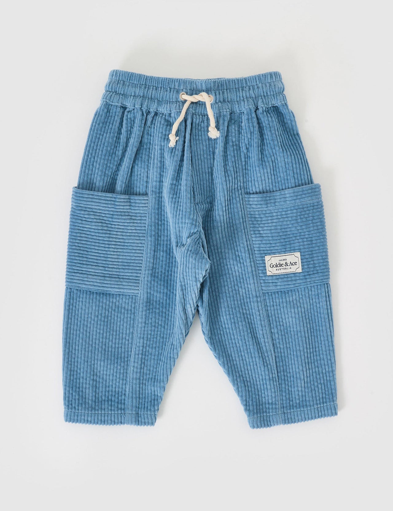 The Goldie + Ace Kit Corduroy Pocket Pant in Duck Egg pictured on a grey background. The material is cotton cord. It is a bottom made for babies, toddlers and kids.