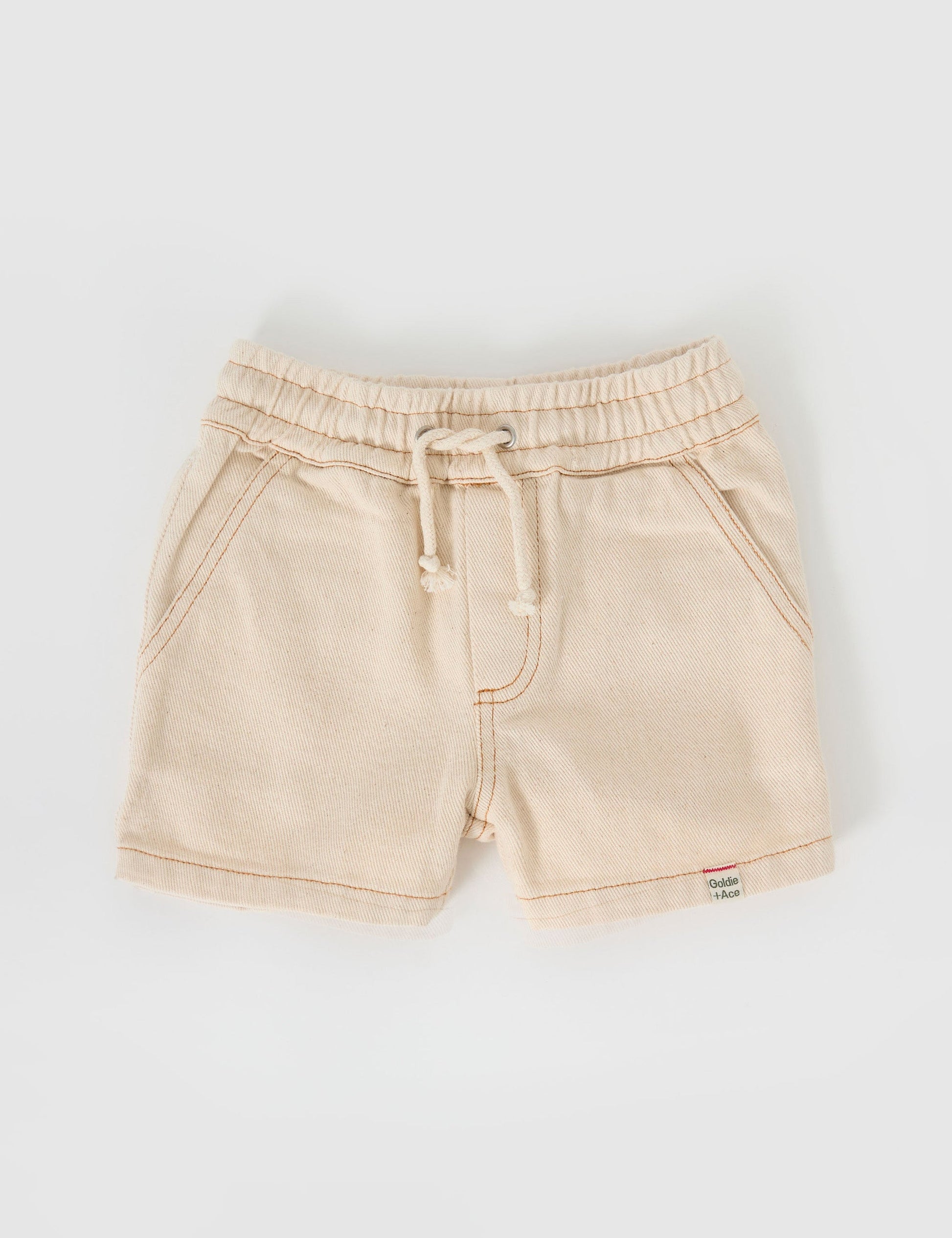 The Goldie + Ace Noah Denim Shorts in Oat pictured on a grey background. The material is cotton twill. It is a bottom made for babies, toddlers and kids.